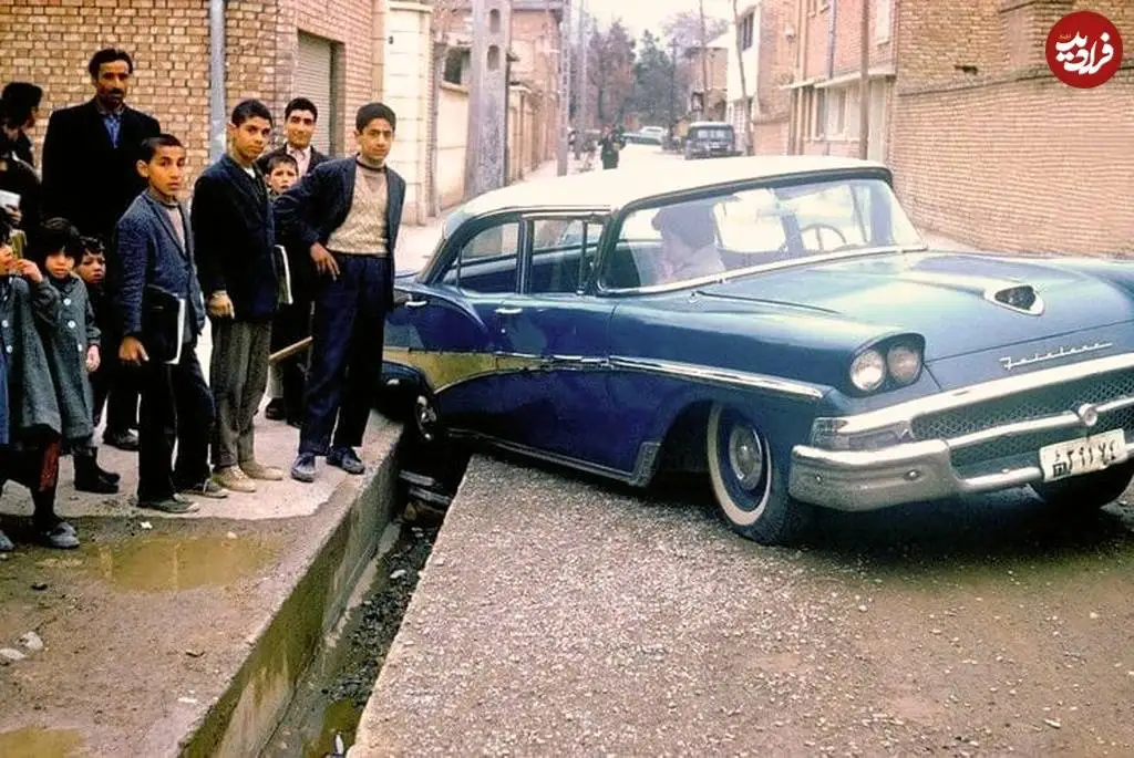(تصویر) تهران قدیم؛ عکس یادگاری اهالی با خودروی فوردی که در جوی آب افتاد؛ سال 41