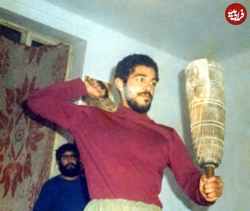 عکس؛ سفر به تاریخ؛ «شهید ابراهیم هادی» در حال انجام حرکات ورزش زورخانه ای در جبهه