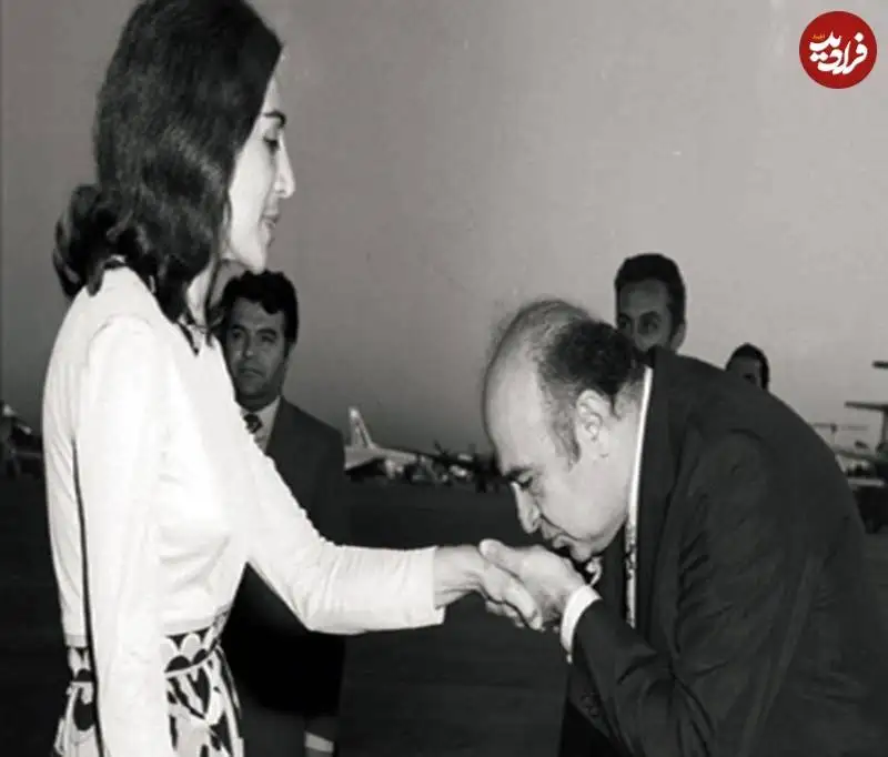 عکس؛ سفر به تاریخ؛ «هویدا» در حال بوسیدن دست «فاطمه پهلوی» خواهر شاه؛ دهۀ 1340
