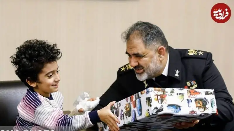 عکس؛ سفر به تاریخ؛ «امیر شهرام ایرانی، فرمانده نیروی دریایی» در کنار فرزند خردسال شهید؛ سال 1401