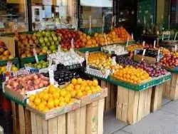 عکس؛ سفر به تاریخ؛ میوه فروش شیرازی که جلوی مغازه اش نشسته است؛ بیش از صد سال قبل